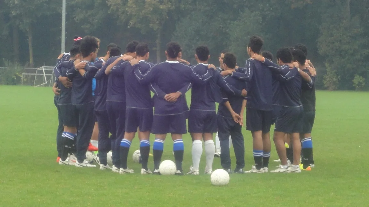 Equipo de fútbol reunido durante un entrenamiento en campo